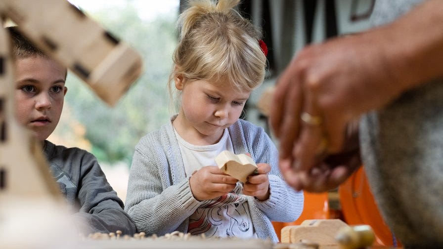 Ken's grandchildren help assemble the wooden cars