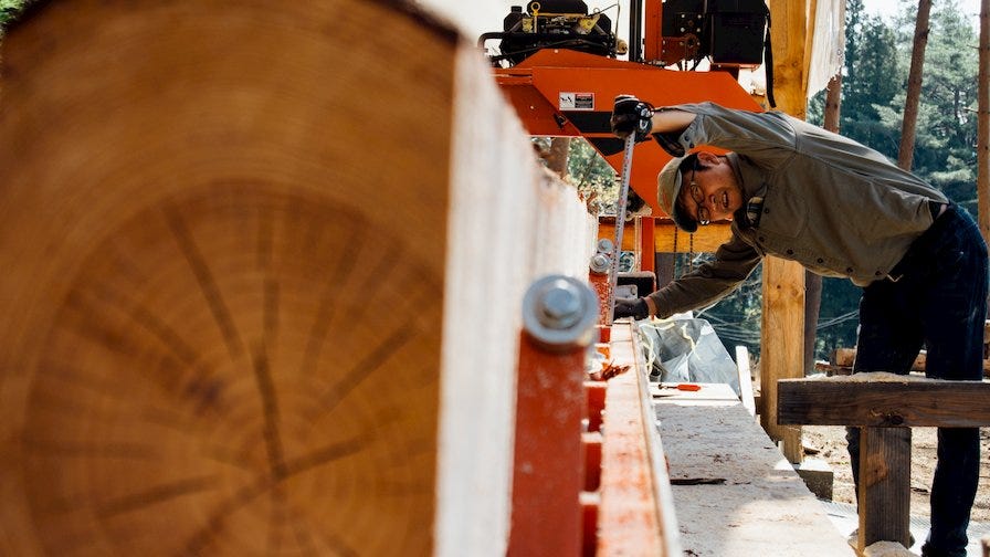 Woodworker turning a log on a portable sawmill